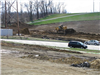View of cars in parking lot and construction equipment moving dirt