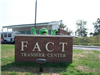 Frog mascot stands behind the FACT Transfer Center sign