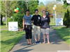 Three Women Posing By Event signs