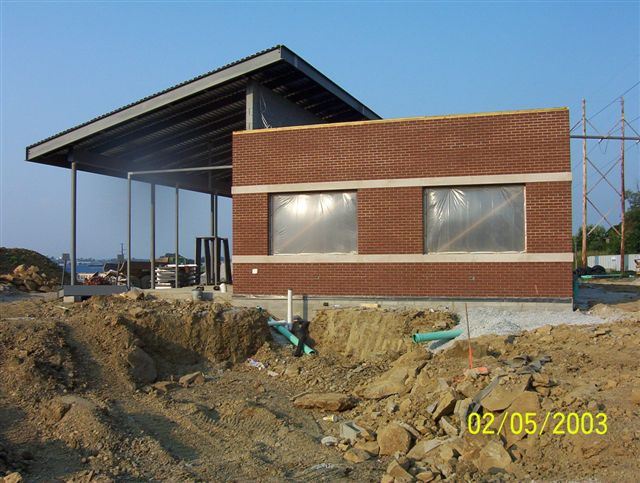 Side of Transfer Center construction site with large hole near building in ground