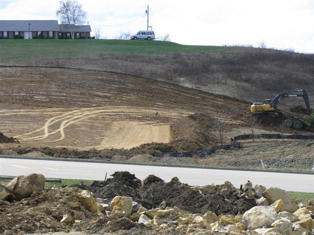 View of large field of dirt being moved during construction