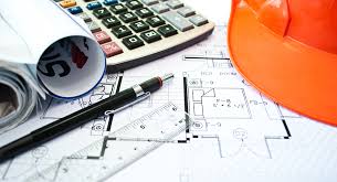 Image of desk with blueprints, calculator, pen and hardhat
