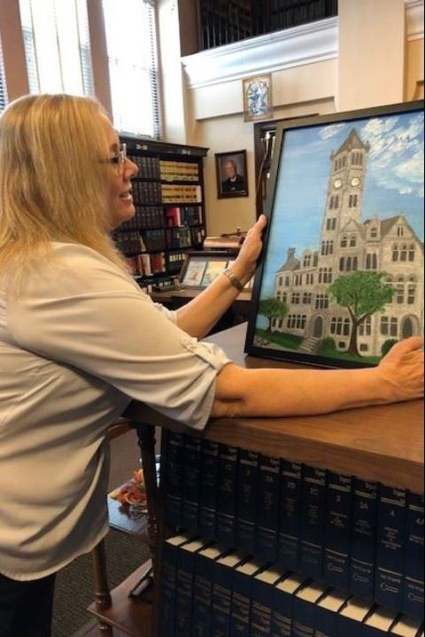 Artist of the Month, Sue Martin, with her painting of the Fayette County Courthouse