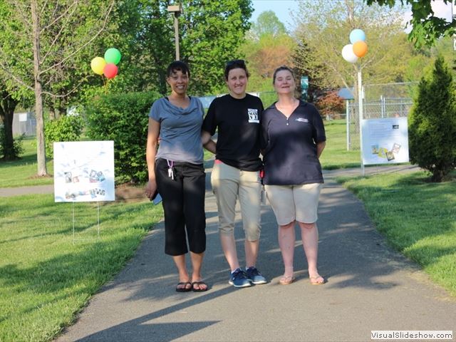 Three Women Posing By Event signs